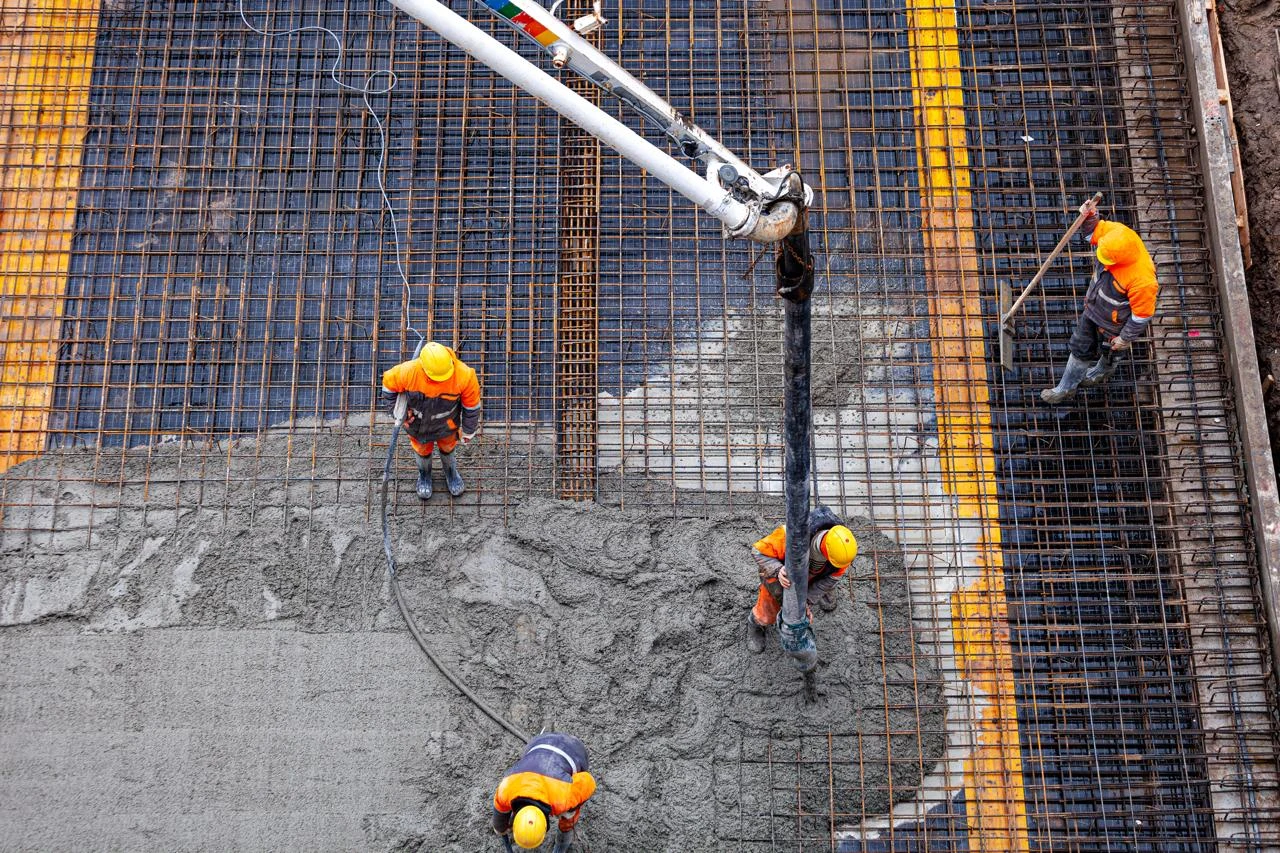 Concrete crew placing a slab over rebar, seen from above